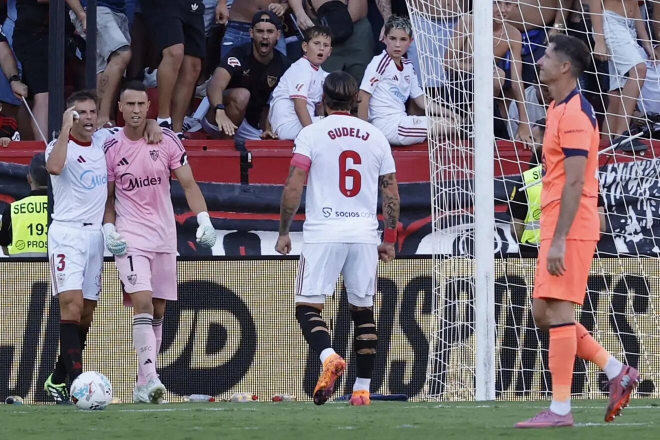 Los jugadores del Sevilla celebran un gol con Lewandowski delante